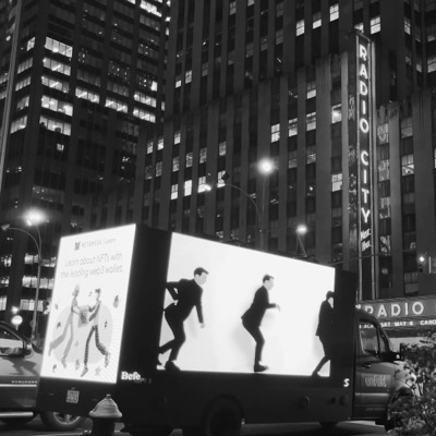 The work on a screen above a New York street at night