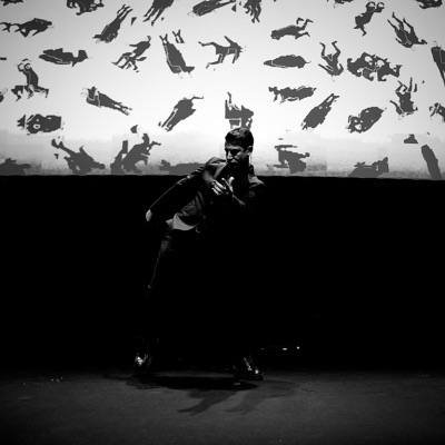 A performance on stage in front of the projected work