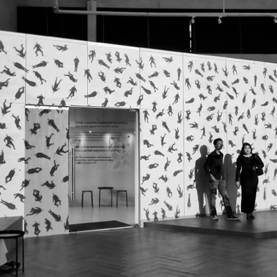 Visitors at a gallery wall hung with the work